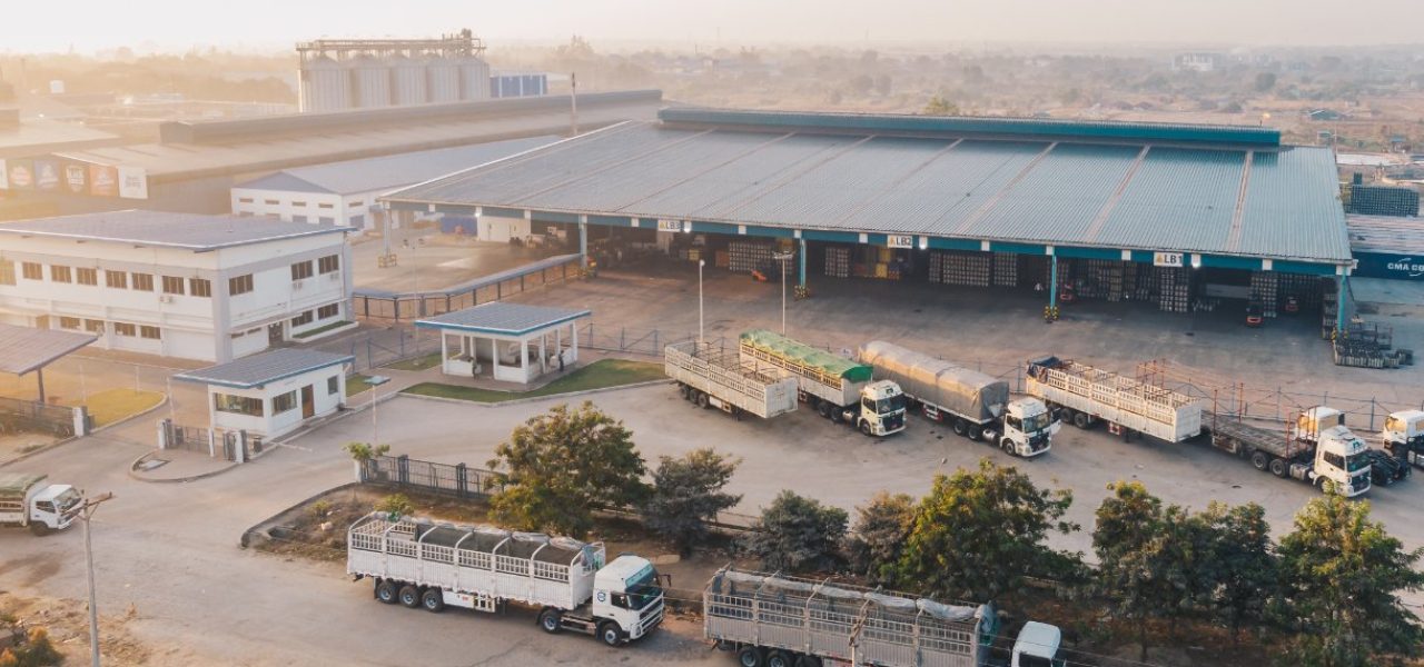 aerial-view-factory-trucks-parked-near-warehouse-daytime